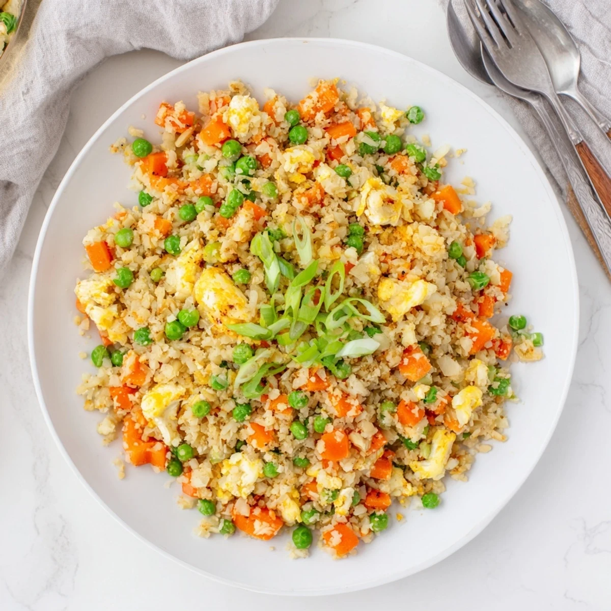 Healthy vegetable cauliflower fried rice plated with tender carrot pieces and fluffy scrambled eggs
