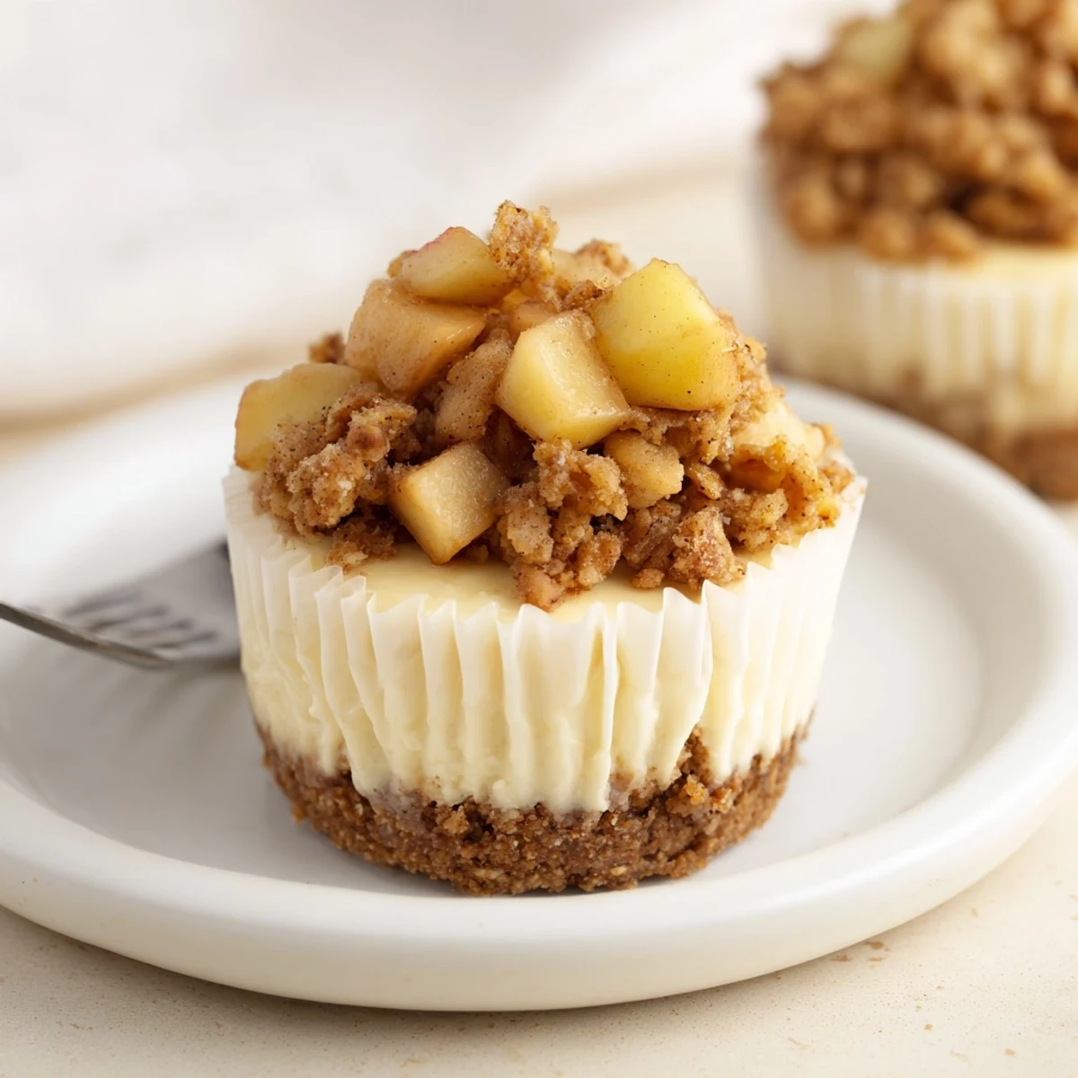 Creamy apple crisp mini cheesecakes with golden spiced oat topping and graham cracker crust
