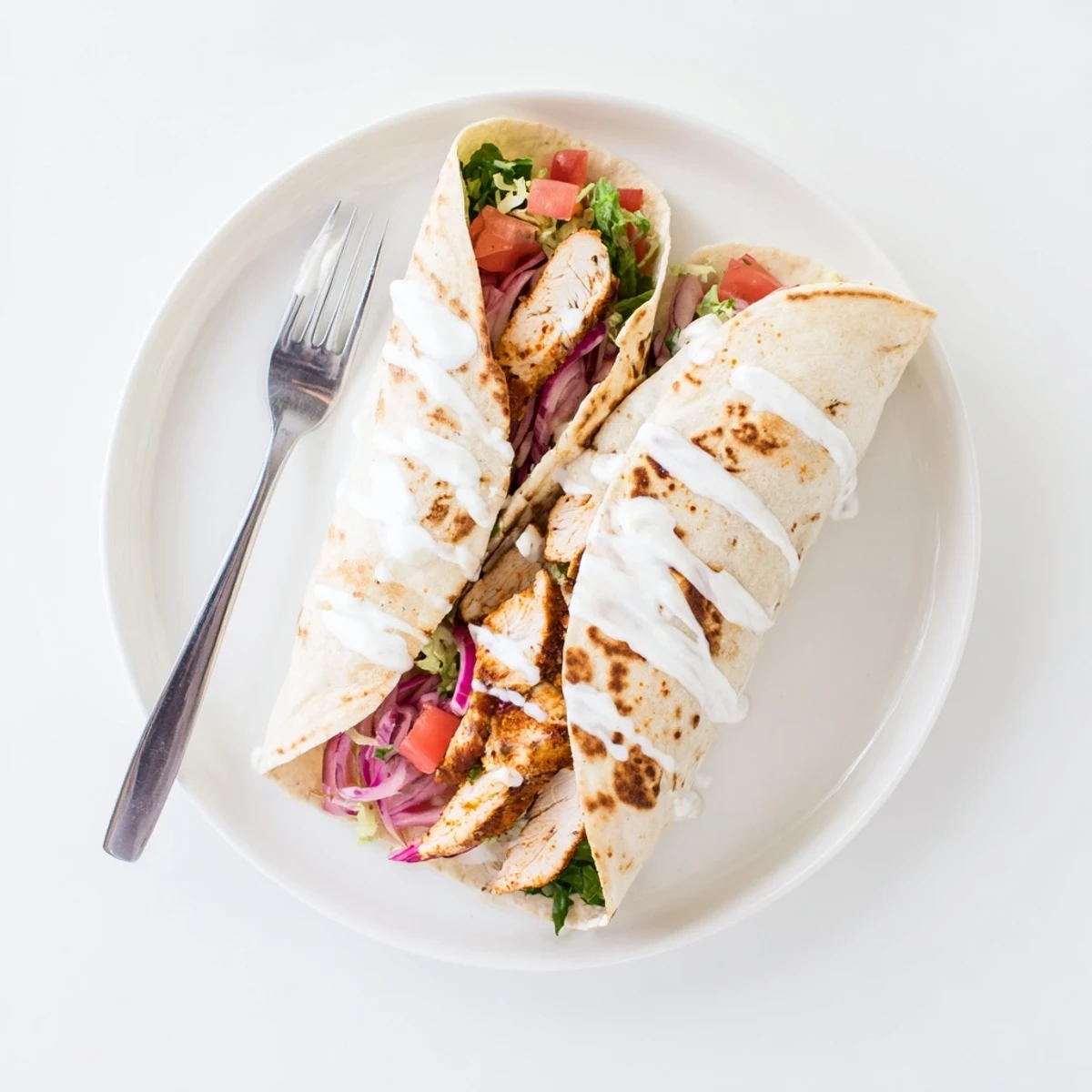 Protein-packed crispy cottage cheese flatbread wraps filled with seasoned grilled chicken lettuce tomato and creamy Greek yogurt topping