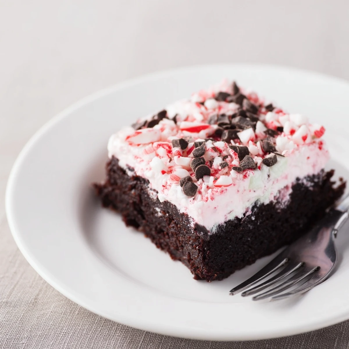 Sliced Peppermint Poke Cake chilled, chocolatey sponge soaked with minty pudding
