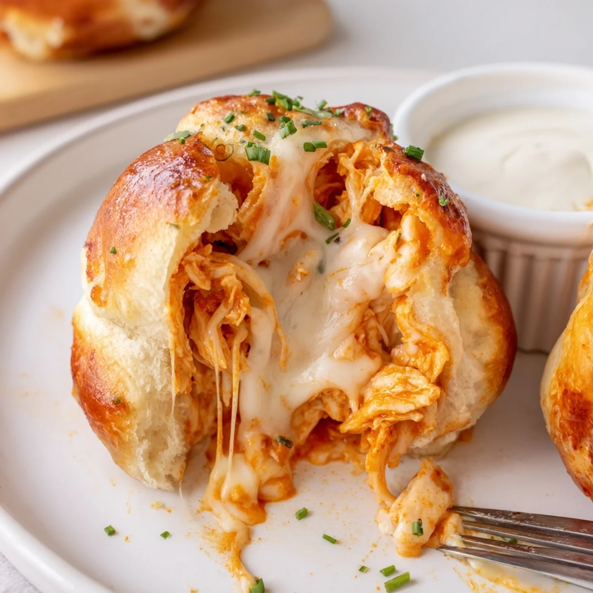Crispy Buffalo Chicken Mozzarella Bombs brushed with garlic butter, cooling on parchment