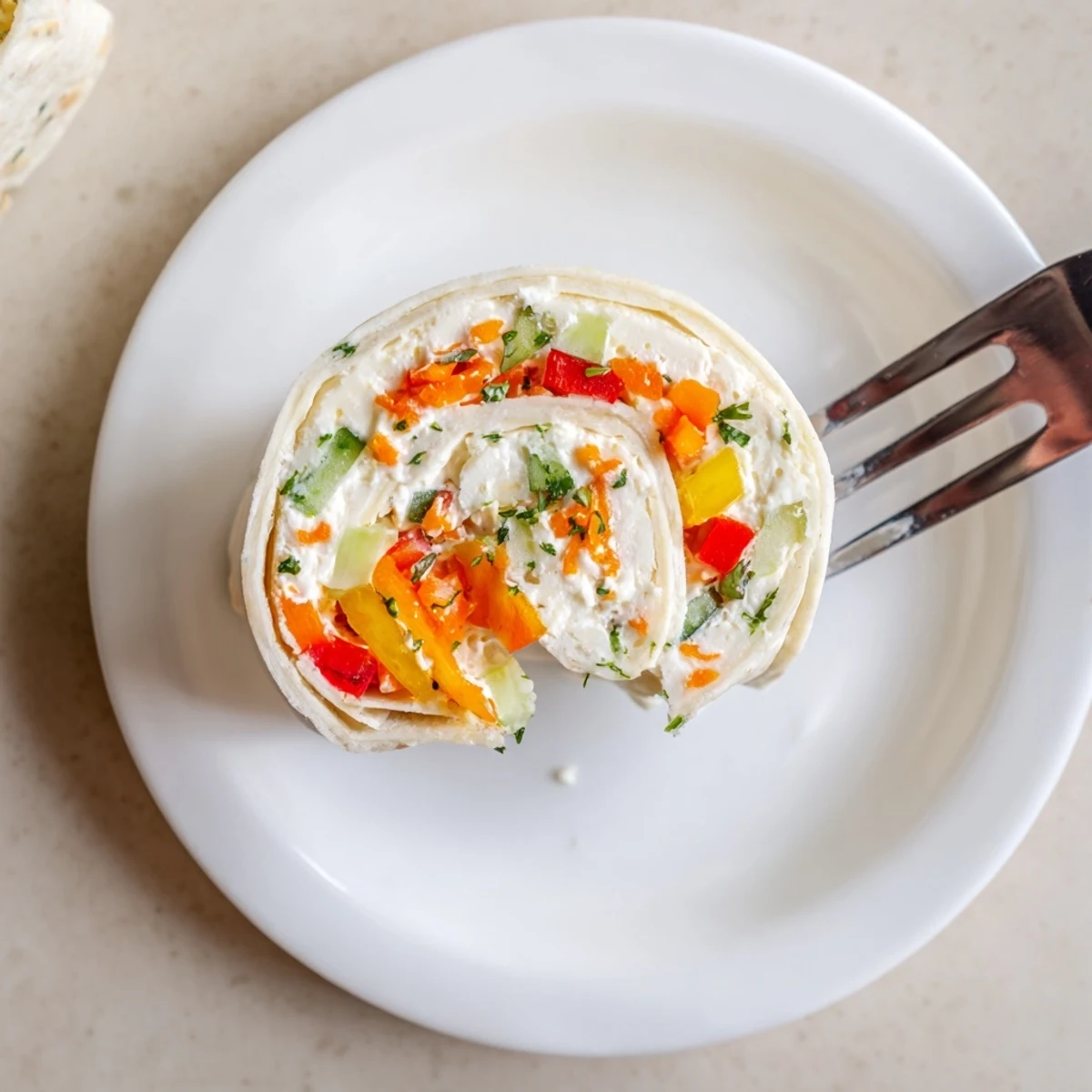 Close-up shows colorful Vegetable Tortilla Roll Ups layered with diced peppers