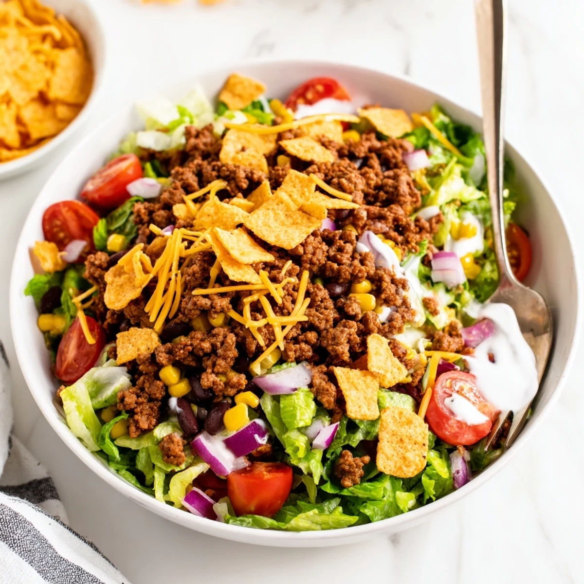 Bright Simple Doritos Taco Salad topped with cheddar, tomatoes, and crisp romaine