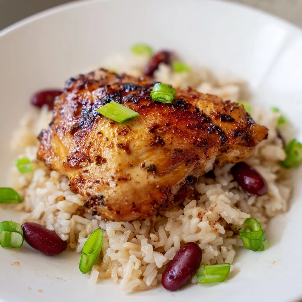 Juicy baked jerk chicken pieces arranged on a bed of creamy white coconut rice