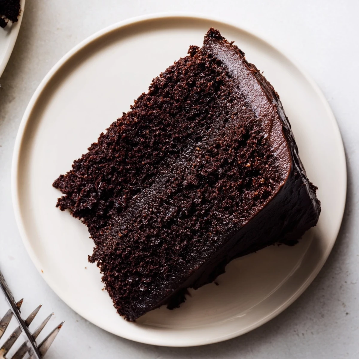 Two-layer chocolate cake made with mayonnaise topped with glossy ganache and chocolate shavings