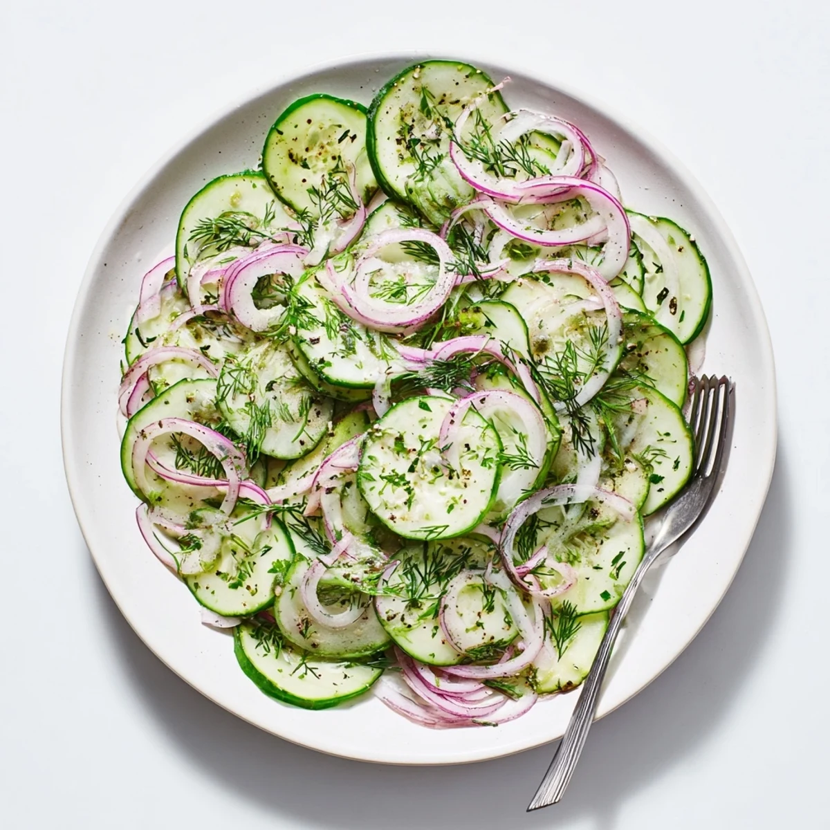 Refreshing cucumber salad with thinly sliced cucumbers, red onions, and fresh dill in a tangy vinaigrette