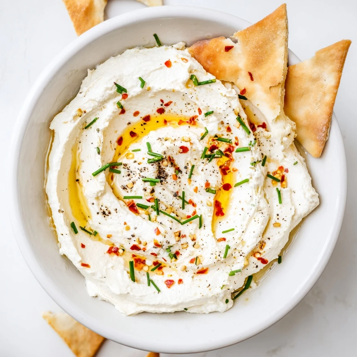 Golden hot honey drizzled over tangy whipped feta spread with black pepper