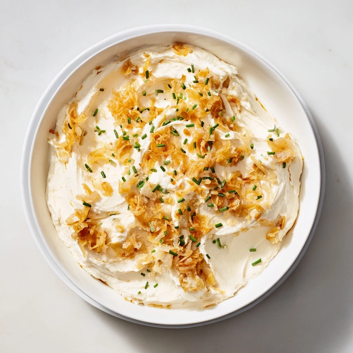 Creamy French onion dip topped with caramelized onions and fresh chives