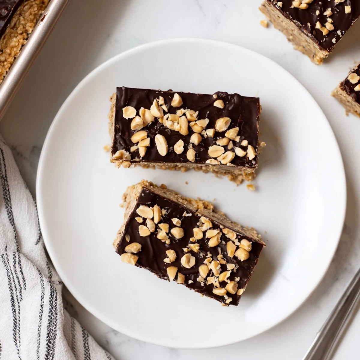 Peanut Butter Bars on parchment lined pan, glossy chocolate topping, cut squares