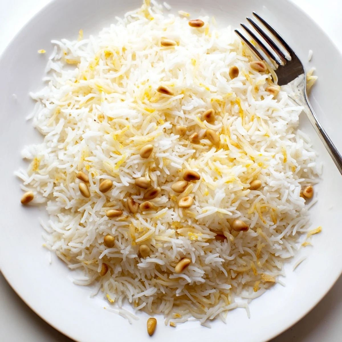 Steaming bowl of Lebanese rice topped with crispy buttery pine nuts