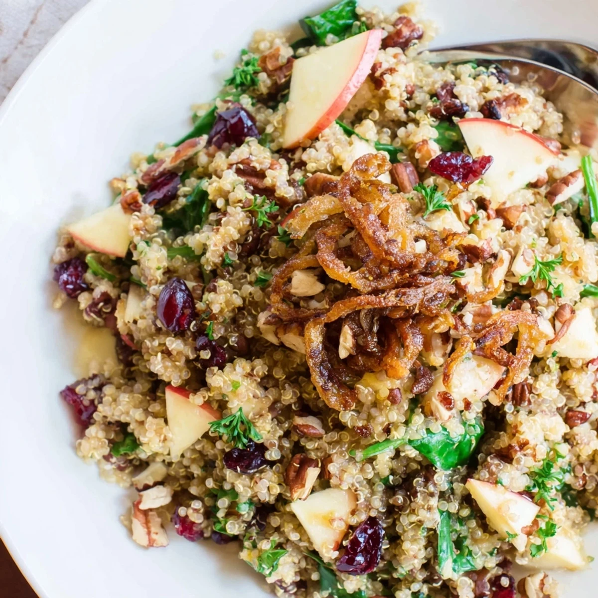 Golden crispy shallots top a colorful honey mustard quinoa apple salad with cranberries and pecans