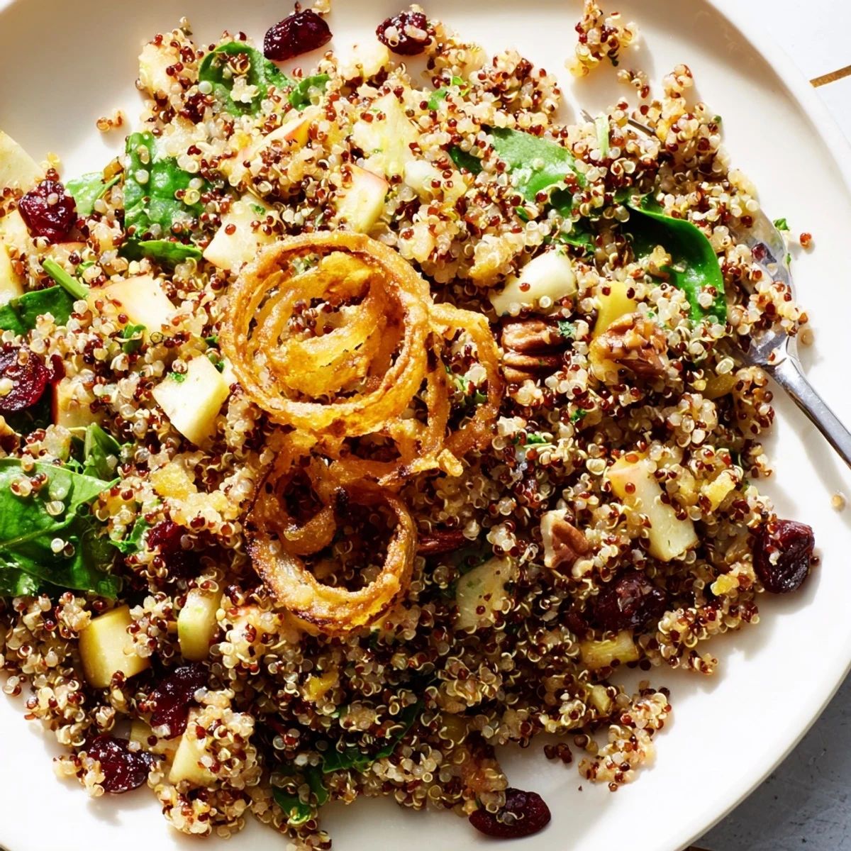 Fluffy quinoa tossed with crisp diced apples in tangy honey mustard dressing served in a white bowl