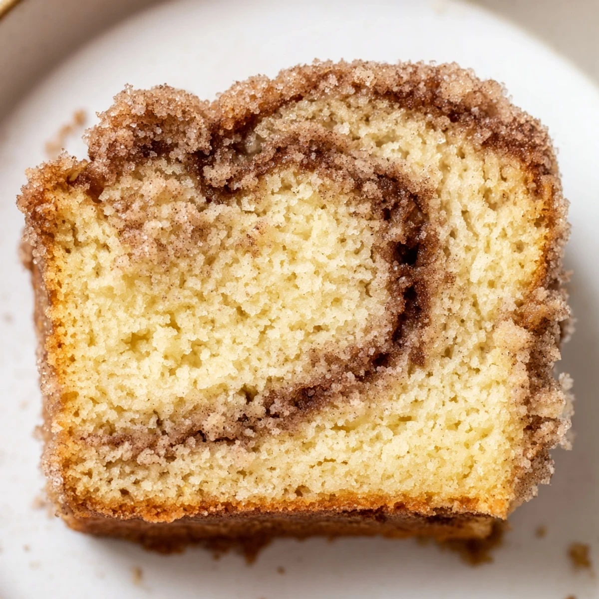 Warm cinnamon donut loaf sliced thick revealing a gooey cinnamon sugar swirl inside