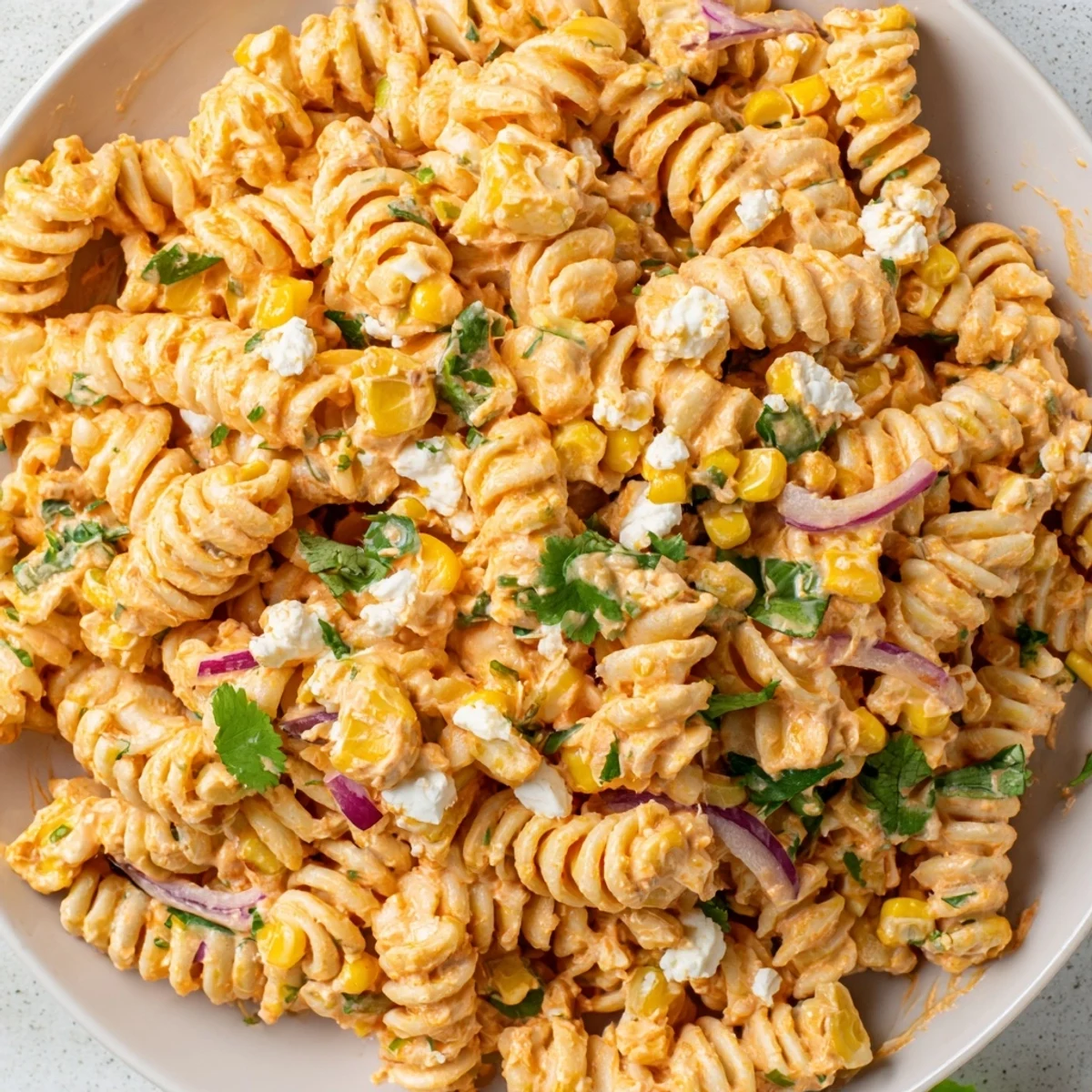 Vibrant elote pasta salad in a smoky lime dressing with sweet golden corn kernels