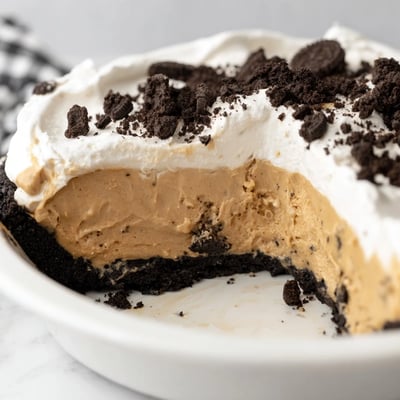 Silky peanut butter Oreo pie sliced to reveal layers of fluffy filling and crust