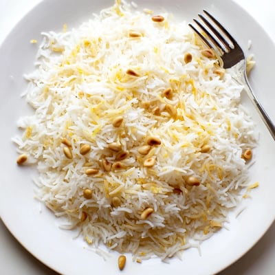 Steaming bowl of Lebanese rice topped with crispy buttery pine nuts