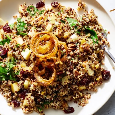 Fluffy quinoa tossed with crisp diced apples in tangy honey mustard dressing served in a white bowl